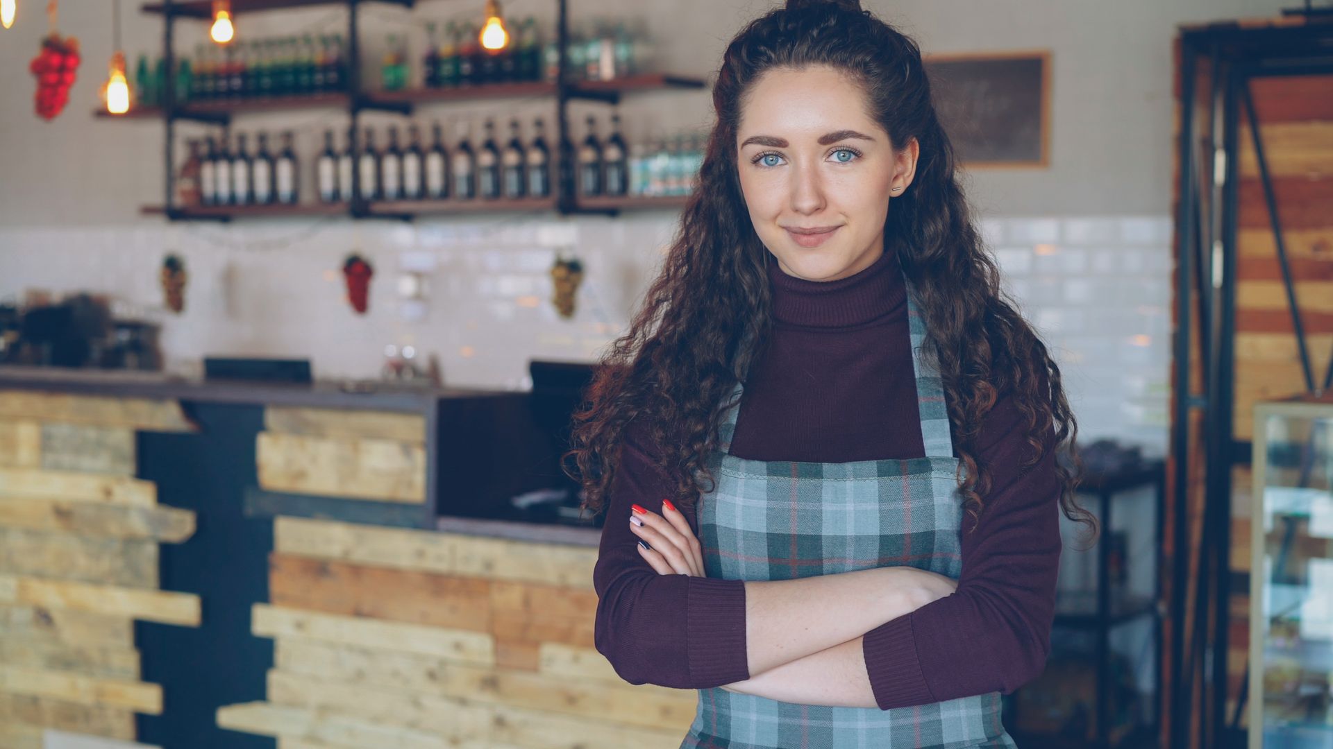 Small cafe owner standing in her coffee shop